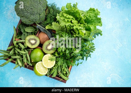 Les légumes verts. Produits frais du jardin. Le brocoli, épinards, kiwi, Laitue, Persil, aneth, asperges, haricots à la chaux béton, fond bleu Banque D'Images