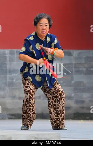 Pratiques de gymnastique traditionnelle vieille dame avec une épée dans le parc Jingshan, à Beijing, en Chine. Banque D'Images