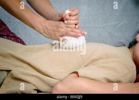 Asian woman getting Thai herbal compress massage in spa Banque D'Images