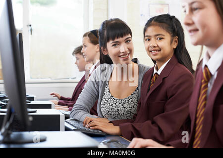 Portrait d'élèves en uniforme en classe avec l'ordinateur Enseignante Banque D'Images