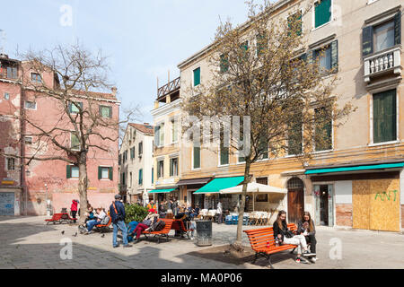 Campo Santa Maria Nova, Cannaregio, Venise, Vénétie, Italie avec les Vénitiens et les touristes assis sur des bancs profitant du soleil d'hiver Banque D'Images