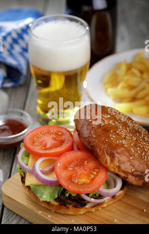 Hamburger délicieux avec des légumes et une côtelette. Sandwich avec de la bière et des frites close-up Banque D'Images