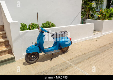 MILOS, GRÈCE - 18 mai 2017 : scooter bleu en stationnement sur rue dans le village de Pollonia sur île de Milos. La Grèce. Banque D'Images