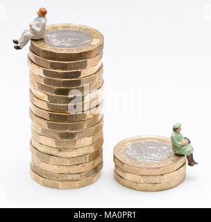 L'égalité de rémunération entre les sexes image conceptuelle de l'homme et de la femme sur une pile de pièces livre Banque D'Images