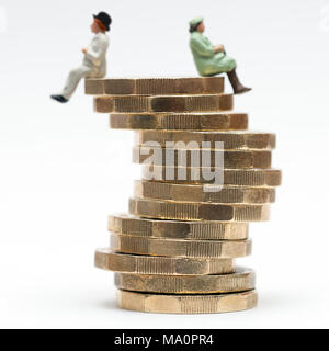 L'égalité de rémunération entre les sexes image conceptuelle de l'homme et de la femme sur une pile de pièces livre Banque D'Images