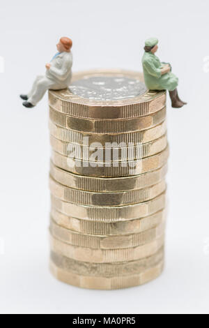 L'égalité de rémunération entre les sexes image conceptuelle de l'homme et de la femme sur une pile de pièces livre Banque D'Images