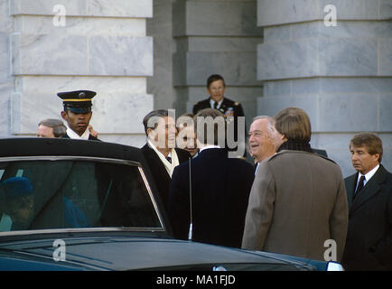 Washington DC. USA, le 20 janvier 1985, le président Ronald Reagan après delvering son 2ème discours inaugural, Reagan est escorté par le Maryland le sénateur Charles Mathais et ils rient à une plaisanterie alors que le président se prépare à obtenir dans la limousine pour rentrer à la Maison Blanche. Première dame Nancy Reagan peut être vu d'entrer dans le siège arrière. C'est l'année qu'il n'y a pas de défilé inaugural que la météo temps ont été sous-zéro à la fois. Credit : Mark Reinstein/MediaPunch Banque D'Images