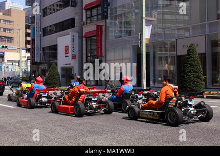 Un groupe de touristes équitation dans location Maricar go-carts en attente à un passage pour piétons à Ginza. (13 avril 2017) Banque D'Images