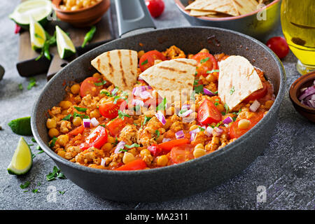 Chili con carne de la Turquie avec les pois chiches servi avec des nachos. Chili avec de la viande, des nachos, citron vert, piment. Mexique / Texas nourriture traditionnelle. Banque D'Images