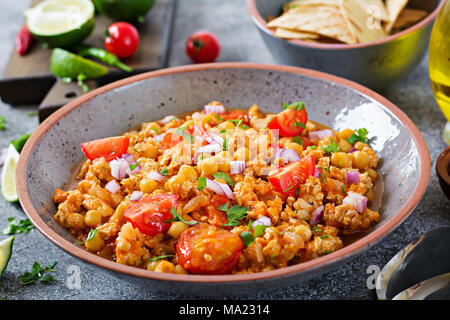 Chili con carne de la Turquie avec les pois chiches servi avec des nachos. Chili avec de la viande, des nachos, citron vert, piment. Mexique / Texas nourriture traditionnelle. Banque D'Images