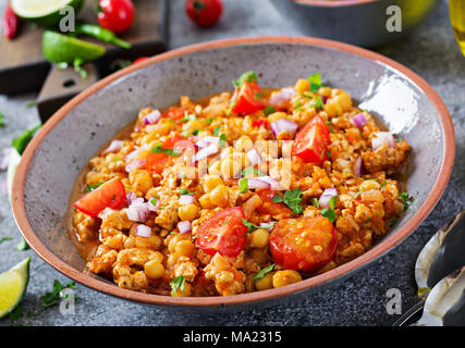 Chili con carne de la Turquie avec les pois chiches servi avec des nachos. Chili avec de la viande, des nachos, citron vert, piment. Mexique / Texas nourriture traditionnelle. Banque D'Images