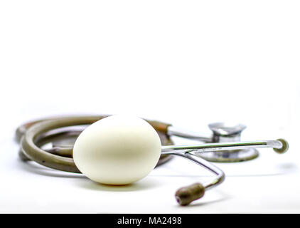 Seul oeuf et stéthoscope isolé en fond blanc comme médecin recommandation santé et nutrition Objectif avec place pour le texte Banque D'Images