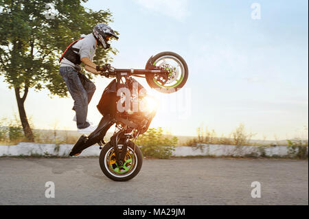 Kiev, Ukraine - 28 août 2015 : weda colorés de Extreme Stunt Driver impressionnant est de sauter sur sa moto sport tout en équitation de façon extrême. Été ensoleillé le soir. Banque D'Images