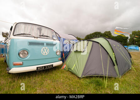 Blanc et bleu Vintage VW Camper van stationné sur un terrain de camping avec une tente à côté, Dorset, England, UK Banque D'Images