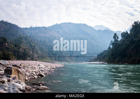 Dans les environs du pont de Rishikesh Inde. Pont suspendu au-dessus de la rivière. Pont de corde longue franchir le ruisseau dans le village Banque D'Images