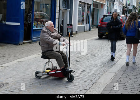 Un homme sur un scooter de mobilité dans la région de Falmouth, Cornwall Banque D'Images