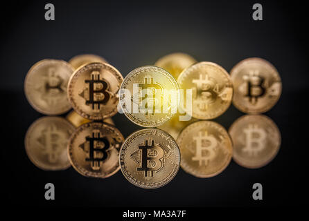 Or de nombreux bitcoins restant sur la surface réfléchissante avec une seule mise au point nette bitcoin Banque D'Images