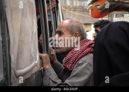 Douma, Syrie. Mar 29, 2018. Un homme à la recherche de sa famille pour la dernière fois après qu'ils ont été approuvés à partir pour Damas, selon des rapports, des civils, pour la plupart des gens malades et blessés qui ont besoin de soins médicaux d'urgence, ont été évacuées de zones tenues par les rebelles dans l'Est de Ghouta Damas sous la supervision du Croissant-Rouge Arabe syrien Crédit : Muhmmad Al-Najjar SOPA/Images/ZUMA/Alamy Fil Live News Banque D'Images