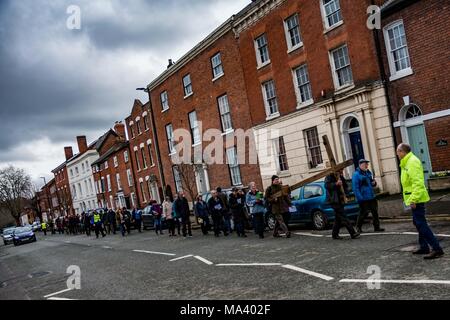 LEOMINSTER, Herefordshire, ANGLETERRE - 30 mars : Les membres de l'Église méthodiste Leominster portent une croix le long de la rue Etnam comme la communauté chrétienne en Leominster se rassemblent pour prendre part à une procession du Vendredi Saint dans le cadre de la Semaine Sainte le 30 mars 2018. Au cours de la marche du témoignage qu'ils portent la croix symbolique de l'Église baptiste sur Etnam le marché médiéval à travers la rue place de la ville à l'Église Priorale sur la rue de l'église où sera érigée la croix. Beaucoup de villes et villages détiennent déjà des marches promenades ou de témoin comme un signe de leur croyance commune en la mort et la résurrection de Jésus Christ. L Banque D'Images