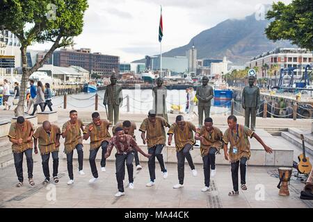 Danseurs en face du quatre sculptures en bronze de lauréats du Prix Nobel de la paix à Cape Town, Afrique du Sud Banque D'Images
