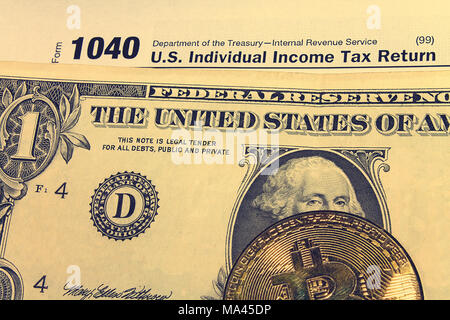 Jour de l'impôt. L'impôt sur le formulaire 1040, dollar et bitcoin est sur une table en bois. Banque D'Images