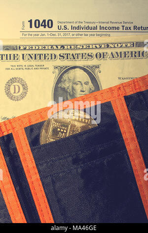 Jour de l'impôt. L'impôt sur le formulaire 1040, dollar, orange noir porte-monnaie et bitcoin est sur une table en bois. Banque D'Images