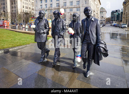 Beatles statues at Pier Head à Liverpool avec bâtonnets de chatouilles ajoutée à la mémoire de Ken Dodd de funérailles le 28 mars 2018 Banque D'Images