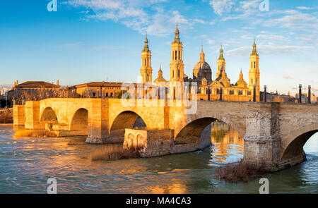 Saragosse - Le pont Puente de Piedra et la Basilica del Pilar dans la lumière du matin. Banque D'Images