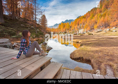 Une femme regardant le petit lac près de Crampiolo connu sous le nom de lac des sorcières, Alpe Veglia et parc naturel Alpe Devero, Baceno, Verbano Cusio Ossola province, Piémont, Italie Banque D'Images