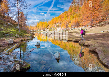 Un touriste à regarder le petit lac près de Crampiolo connu sous le nom de lac des sorcières, Alpe Veglia et parc naturel Alpe Devero, Baceno, Verbano Cusio Ossola province, Piémont, Italie Banque D'Images