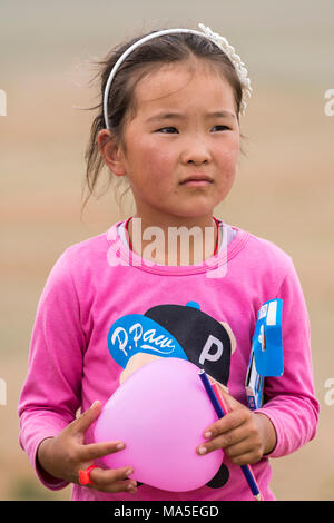 Portrait d'une petite fille avec un ballon rose dans les mains. Province sud de Gobi, en Mongolie. Banque D'Images