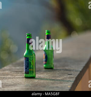 Deux bouteilles de bière verte vide abandonnée le haut d'un mur sur le mont Janicule, Rome, Italie. Banque D'Images