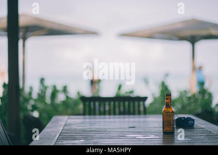 Cendrier et une bouteille de bière seul sur une table dans un club de plage sur l'île de Bonaire Banque D'Images