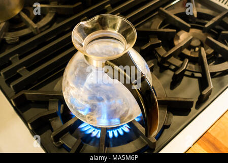 D'ébullition de l'eau dans une bouilloire sifflante en verre par Medelco sur une plaque de cuisson Banque D'Images