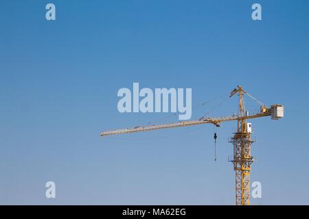 Grue a tour sur un chantier de construction sur le fond de ciel bleu Banque D'Images