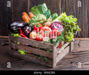 Multi-couleur fraîche de légumes dans des caisses en bois. Fond de bois. Banque D'Images