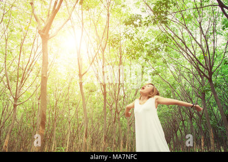 Vie des femmes concept : Beautiful young asian woman stretching et de bâiller à l'air frais dans la forêt verte Banque D'Images