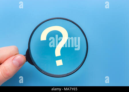 Point d'interrogation sous une loupe avec fond bleu Banque D'Images