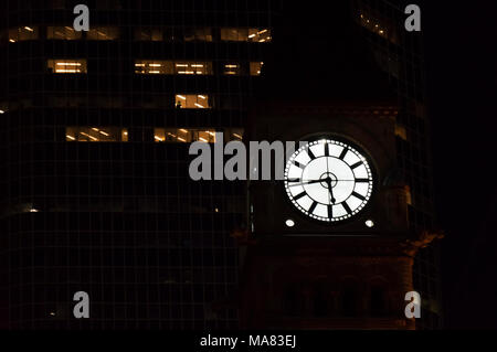 Le temps s'infiltre dans le noir même si vous mettez t avis. L'ancien hôtel de ville de Toronto avant le tour de l'horloge de gratte-ciel dans la nuit. Banque D'Images