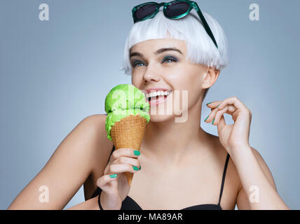 Happy fashion girl enjoying Glace Pistache sur fond bleu. Vie heureuse Banque D'Images