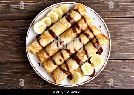 Crêpes délicieux rouleau avec des tranches de banane sur fond de bois. Haut de la vue, télévision lay Banque D'Images