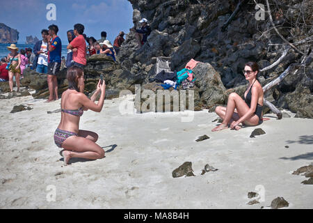 Femme de prendre une photo de son amie à l'aide d'un smartphone. Femme bikini beach. Banque D'Images