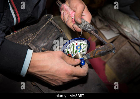Maroc, Fès, quartier des potiers, poterie, décoration argent soudage travailleur sur le couvercle du pot Banque D'Images