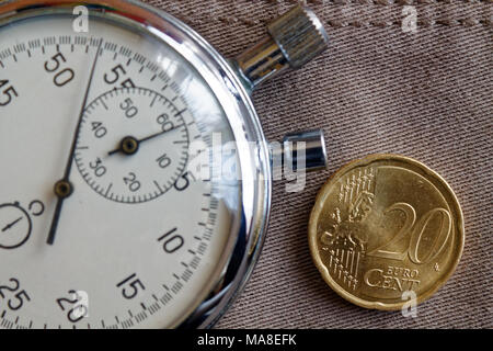 Pièce en euros d'une valeur nominale de 20 centimes d'euro et le chronomètre sur toile Denim beige usé - business background Banque D'Images