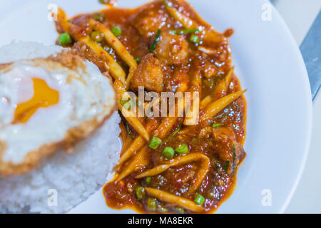 Croustillant de basilic porks et pousses de bambou avec du riz Jasmin sur plaque blanche à table en bois en Thaïlande en tant que favorite locale thaïlandaise l'alimentation de rue. Banque D'Images