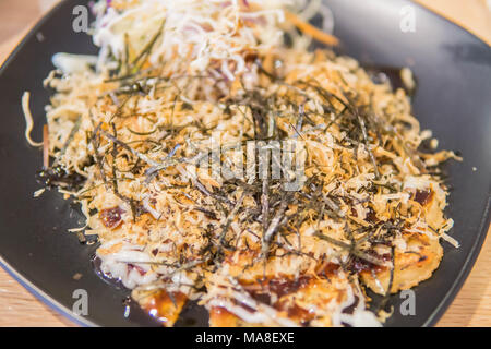 Style japonais KANSAI Okonomiyaki ,salé crêpe ou connu sous le nom de pizza japonaise ce plat peut facile à faire à la maison. Banque D'Images