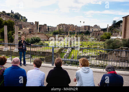 D'un point de vue sur la Via dei Fori Imperiali en vue du Forum Romain un guide raconte l'histoire de l'endroit d'un groupe de touristes en Banque D'Images
