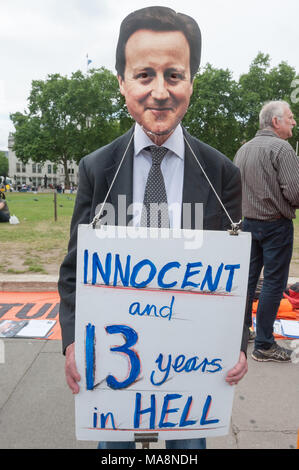 Un manifestant portant un masque de Cameron détient une affiche 'innocent et 13 ans dans l'Enfer" à la veillée hebdomadaire par Free Shaker Aamer campagne électorale en face du Parlement. Banque D'Images