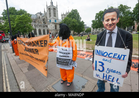 Un manifestant portant un masque de Cameron détient une affiche 'innocent et 13 ans dans l'Enfer" à la veillée hebdomadaire par Free Shaker Aamer campagne électorale en face du Parlement. Banque D'Images