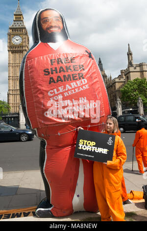 Tania Mathias, élu le mois dernier en tant que député conservateur de Twickenham, pose avec une amnistie poster 'Stop à la torture' et un Shaker Aamer gonflables géants en face de Big Ben. Banque D'Images